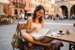 Couple planning a budget vacation with a map, travel notebook, and calculator on a wooden table